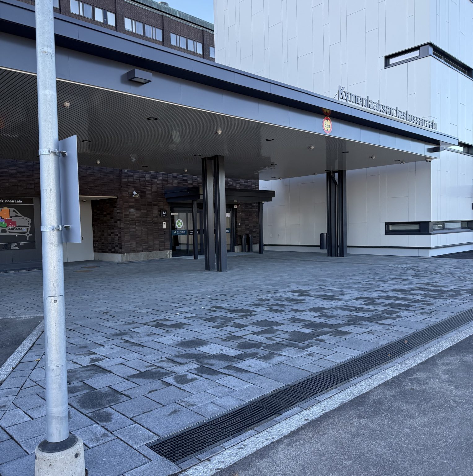 Koksin pääovien edessä on tolppa, joka merkitsee pysäkin paikan.