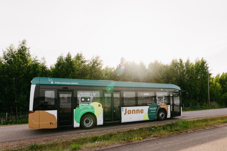 bussi ajaa kesäisellä tiellä